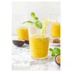 Fresh mango smoothie in glass with mint garnish for healthy drinking.