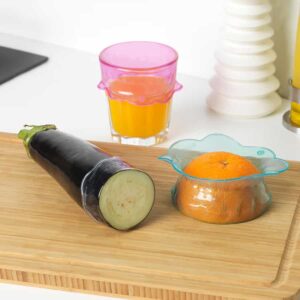 Vivid pink and blue transparent containers for fruits and vegetables, ideal for kitchen organization.