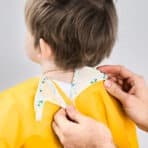 Child painting apron with adjustable neck strap and waterproof material.