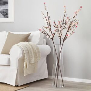 Beautiful cherry blossom branches in a tall glass vase for elegant home décor.