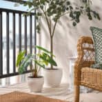 Bright balcony with lush potted plants and wicker chair, perfect for relaxing or outdoor decor.