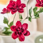 Vivid red artificial flower suitable for home, office, and event decoration. High-quality silk floral arrangement.