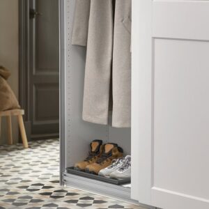 Stylish gray slippers and sneakers organized inside a modern closet for home.