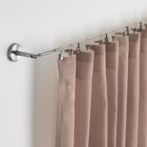 Stainless steel curtain wire with beige curtains for home decor.