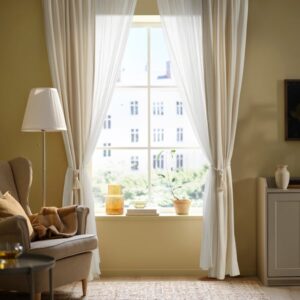 Bright living room with off-white curtains and cozy furniture.