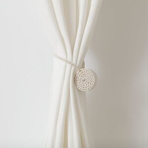 Beige and white magnetic curtain tie-back for window curtains.