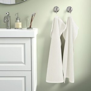 White GULVIAL hand towels hanging on wall hooks in bathroom.