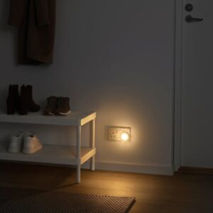 White LED nightlight with sensor illuminating a hallway corner.