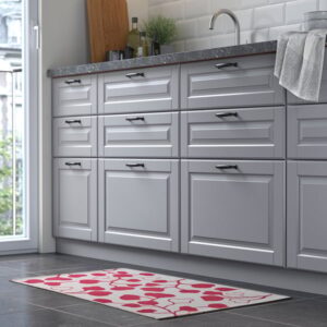 Contemporary kitchen with gray cabinets and pink/leaf patterned rug.