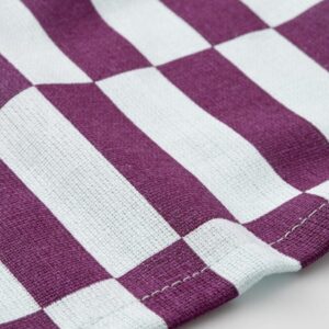 Colorful patterned tea towel with purple and white checkered design.