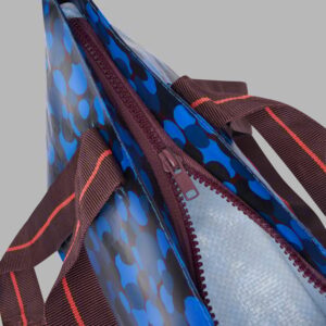 Blue patterned carrier bag with zipper and handles for shopping or carrying items.