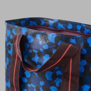 Blue patterned carrier bag with handles and zipper for shopping or storage.